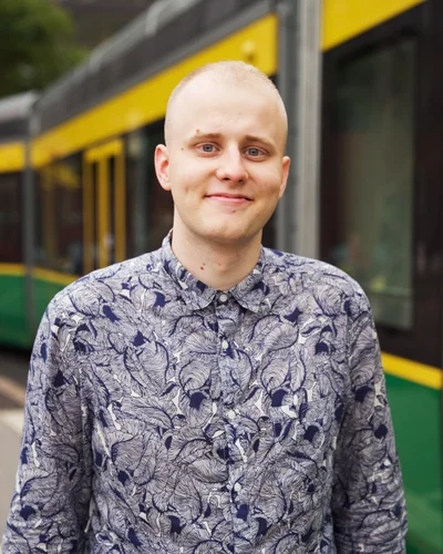 Akseli hymyilee, taustalla helsinkiläinen raitiovaunu
